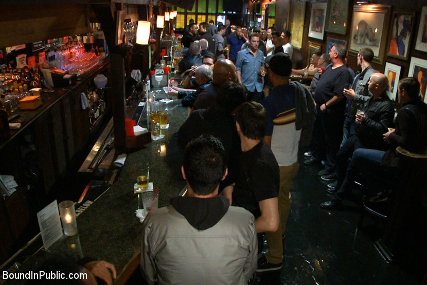 Kink Men 'Naked ripped stud gets humiliated and used in a crowded public bar.' starring Adam Herst (Photo 1)